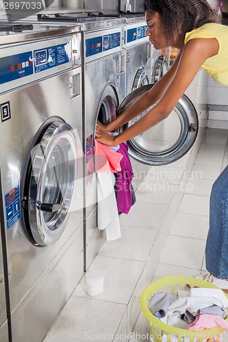 Image of Woman Loading Washing Machine With clothes