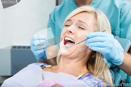 Image of Dentist Treating A Female Patient At Clinic