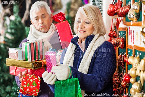 Image of Happy Woman Shopping Presents With Tired Man