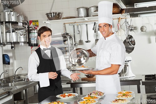 Image of Waiter Taking Customer's Food From Chef