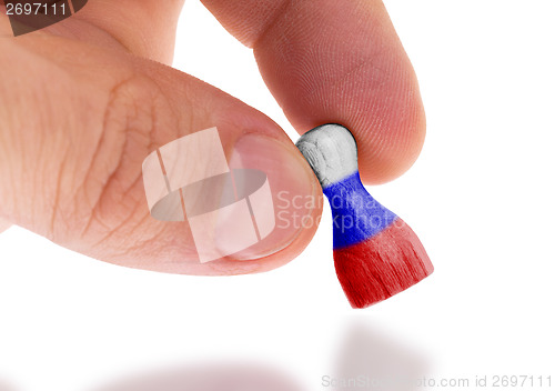 Image of Hand holding wooden pawn, flag painting, selective focus