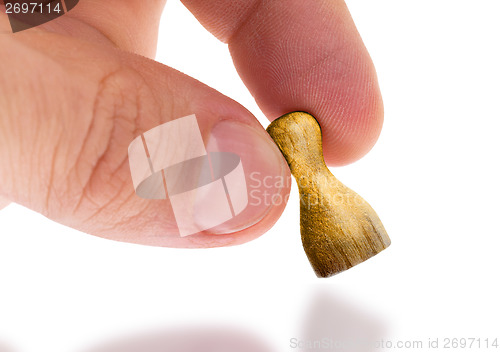 Image of Hand holding wooden pawn, painting, selective focus