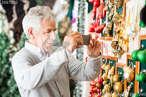 Image of Man Photographing Christmas Ornaments