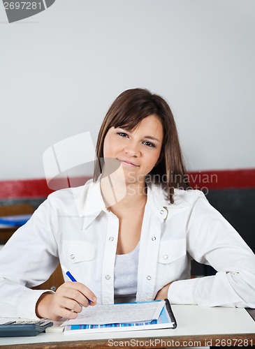 Image of Beautiful Teenage Schoolgirl Sitting At Desk