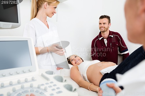 Image of Gynecologist Showing Digital Tablet To Couple