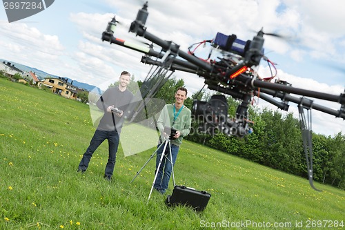 Image of Engineers Flying UAV Helicopter in Park