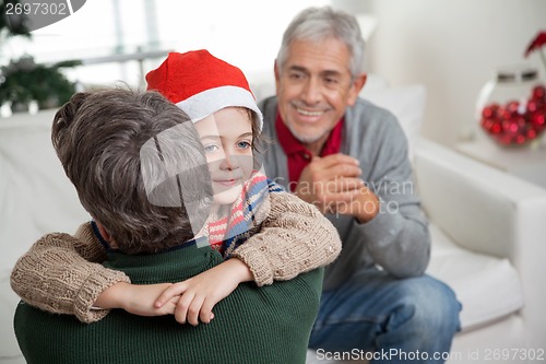 Image of Son In Santa Hat Embracing Father