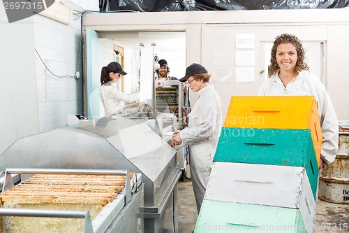 Image of Female Beekeeper Holding Trolley Of Stacked Honeycomb Crates