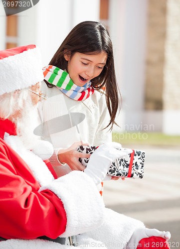 Image of Surprised Girl Taking Gift From Santa Claus