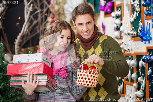 Image of Man With Woman Shopping Presents In Christmas Store