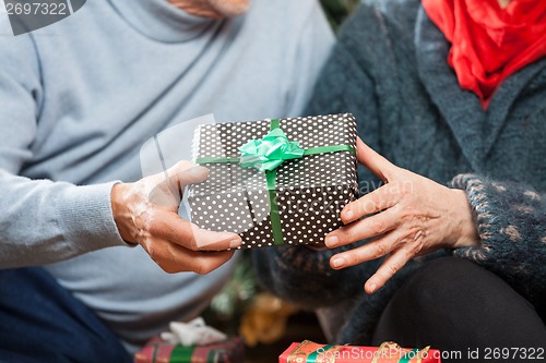 Image of Couple Holding Christmas Present At Store