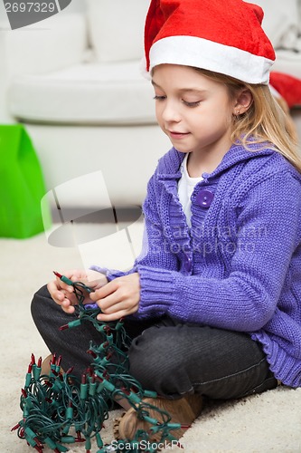 Image of Girl In Santa Hat With Fairy Lights