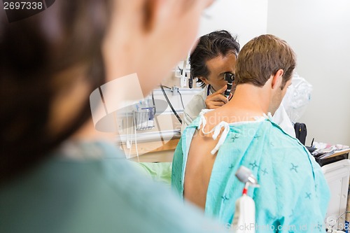 Image of Doctor Using Otoscope To Examine Patient's Ear