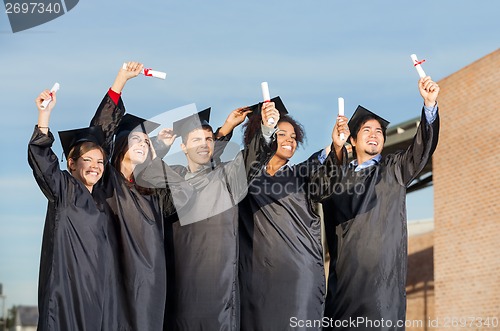 Image of Students With Diplomas Standing Together On University Campus