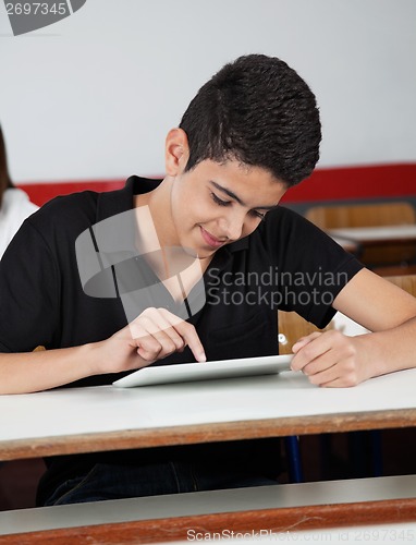 Image of Happy Teenage Schoolboy Using Tablet At Desk