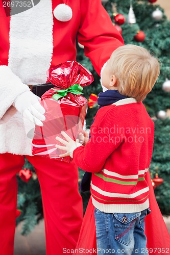 Image of Santa Claus Giving Present To Boy