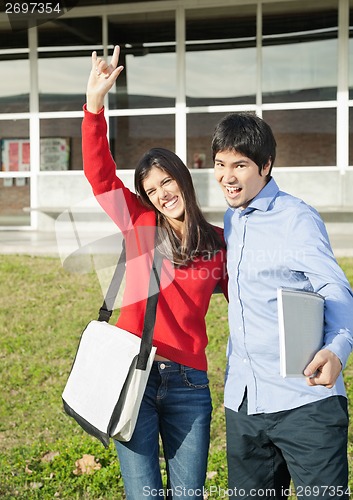 Image of Man With Friend Gesturing Devil Horns On College Campus