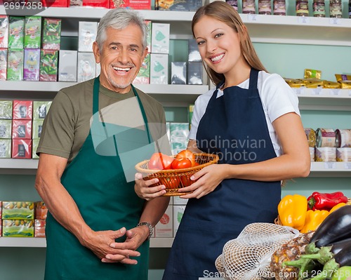 Image of Saleswoman Holding Vegetable Basket With Male Colleague In Groce