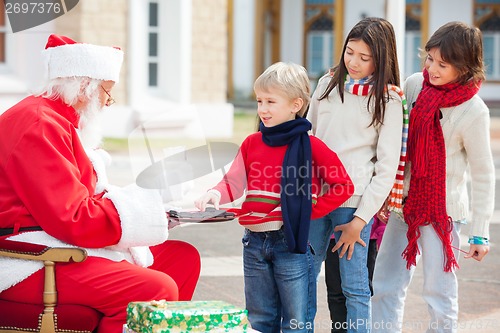 Image of Boy Taking Biscuits From Santa Claus