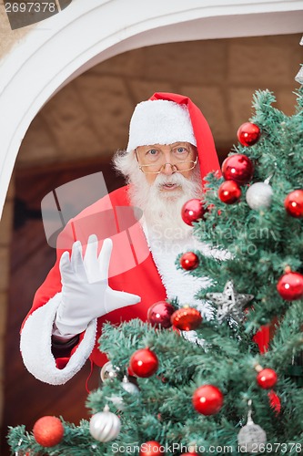 Image of Santa Claus Gesturing From Christmas Tree