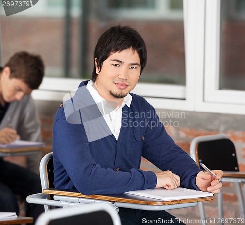 Image of Confident Student Sitting At Desk In Classroom