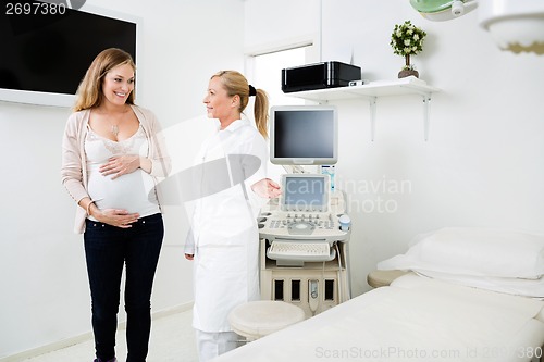 Image of Gynecologist Showing Bed To Pregnant Woman