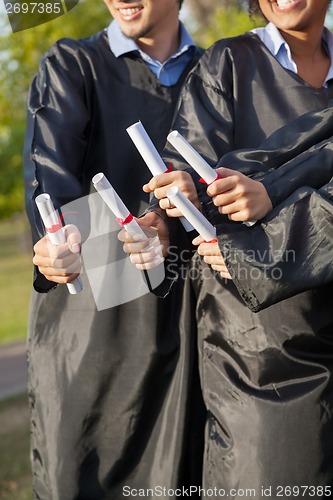 Image of Students Holding Diplomas On Graduation Day In College