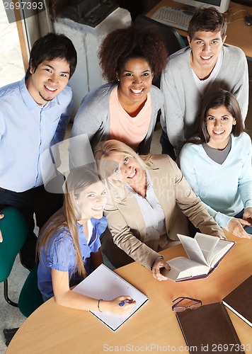 Image of Teacher And Students With Books Smiling In Classroom