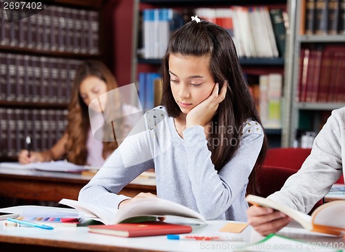 Image of Girl Reading Book At Desk With Friends