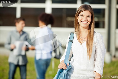 Image of Woman Carrying Shoulder Bag With Students In Background On Campu