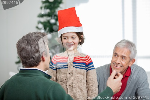 Image of Father And Grandfather Looking At Son During Christmas