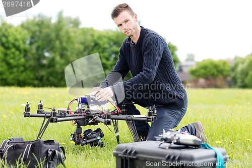 Image of Young Engineer Preparing Spy Drone in Park