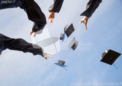 Image of Students Throwing Mortar Boards In Air Against Sky