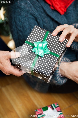 Image of Couple Holding Christmas Present At Store