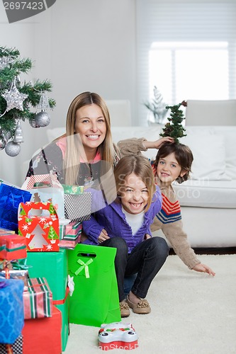Image of Mother With Children Sitting By Christmas Gifts