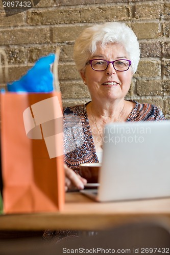 Image of Senior Woman With Laptop In Coffeeshop