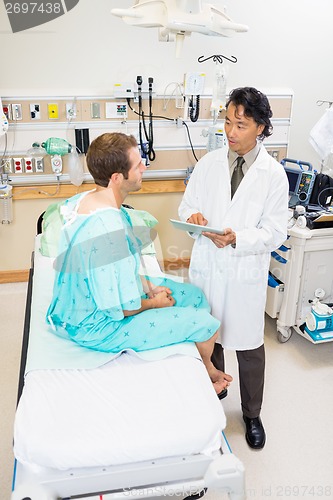 Image of Doctor Discussing Report Over Digital Tablet With Patient