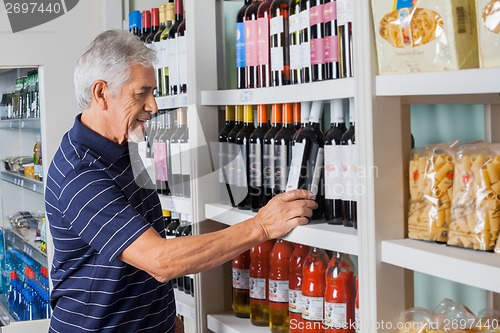 Image of Senior Man Choosing Wine At Supermarket