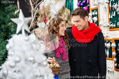 Image of Couple With Bauble Basket In Christmas Store