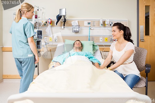 Image of Woman Holding Patient's Hand While Looking At Nurse