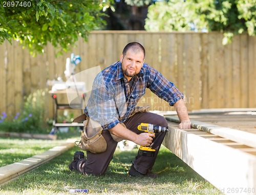 Image of Manual Worker Drilling Wood At Construction Site