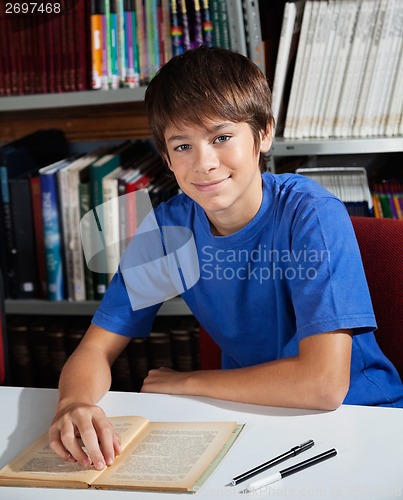 Image of Teenage Schoolboy Smiling While Sitting In Library