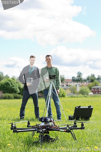 Image of Technicians Holding Remote Controls Of UAV Helicopter