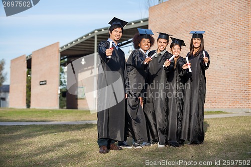 Image of College Students Showing Diplomas Standing On Campus