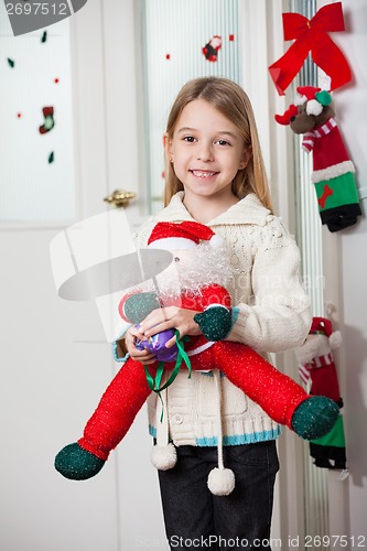 Image of Girl With Santa Toy Standing At Home