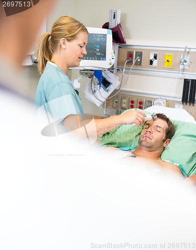 Image of Nurse Examining Male Patient in Emergency