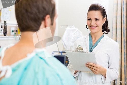 Image of Doctor With Clipboard Examining Patient's Medical Report
