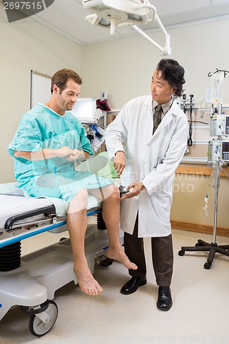 Image of Neurologist Examining Patient's Knee With Hammer In Hospital