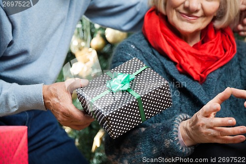 Image of Man Giving Christmas Present To Woman At Store