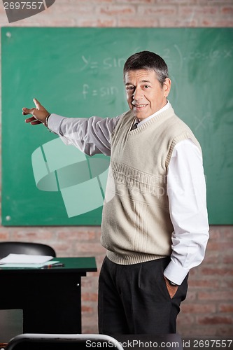 Image of Teacher Pointing Towards Greenboard At Classroom